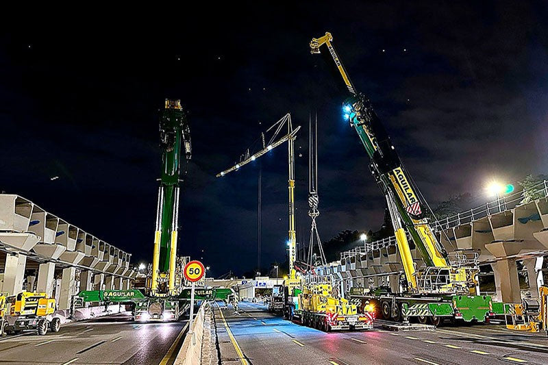 Grúas Aguilar Liebherr mobile cranes working at night over the M-30 motorway on the Parque Ventas project in Madrid, Spain