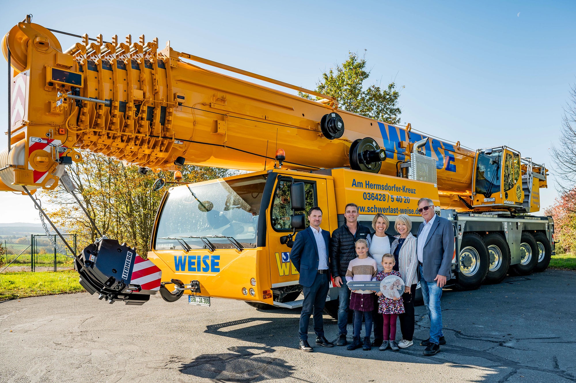 Crane handover to three Weise generations in Mörsdorf: (from left to right) Sven Bahms (Liebherr-Werk Ehingen GmbH), Walter Weise-Kahlert, Anja Weise, Roswitha Weise and Hermann Weise, with Klara and Anna Weise in front (all Schwerlast Weise GmbH)