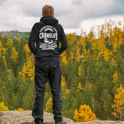 White man wearing a black crane life hoodie while on a hike with a forest with leaves changing