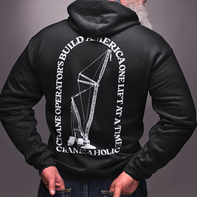 White male with beard wearing crane operator bella canvas hoodie with a DTG printed crane operator design on the back and blue jeans