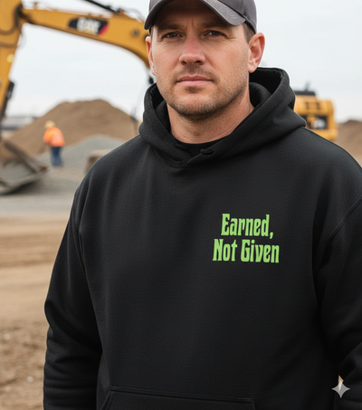 Man wearing a black hoodie with 'Earned, Not Given' text in a construction setting