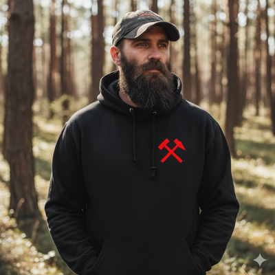 Man wearing a black hoodie with a red logo in a forest