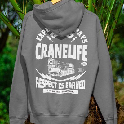 Gray crane life hoodie hanging on a palm tree