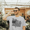 A model with sunglasses at a flower shop wearing american tower crane operator gray T shirt smiling