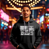 African American male with a black bella canva hoodie on with a white DTG design printed on the front of the hoodie standing on a busy night lift street