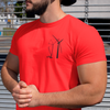 Muscular hispanic male wearing a bright red t shirt on the street with a DTG printed design of a crane building a wind turbine