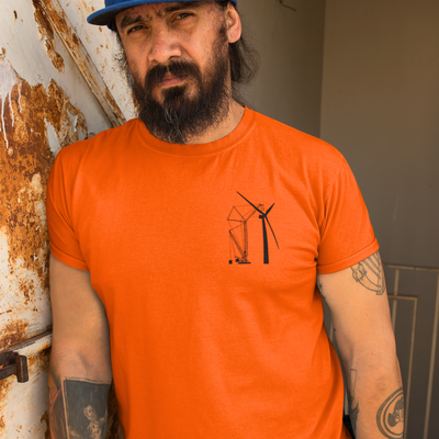 Man with a black scruffy beard wearing a bright orange high vise work shirt that shows a crane building a wind turbine