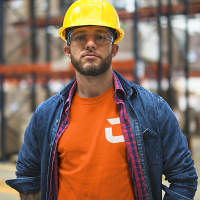 Man at work with yellow hard hat, clear safety glasses wearing a orange craneaholic t shirt with C logo DTG printed on the front