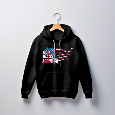 A black hoodie hanging on a wooden hanger against a white background. The hoodie features "God Bless America" printed on the front in a distressed American flag design.