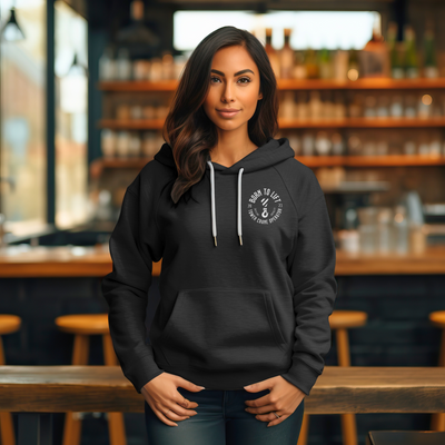 Women with brown hair wearing a black unisex skyline legends lift crane operator, front view with logo at a bar