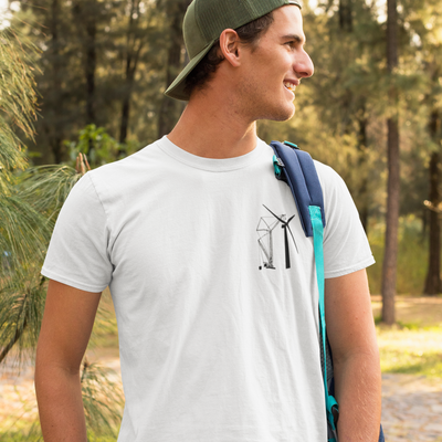 Clean shaved white male on a hike wearing a white t shirt with a DTG printed design of a crane building a wind turbine on the front of his shirt while in the woods